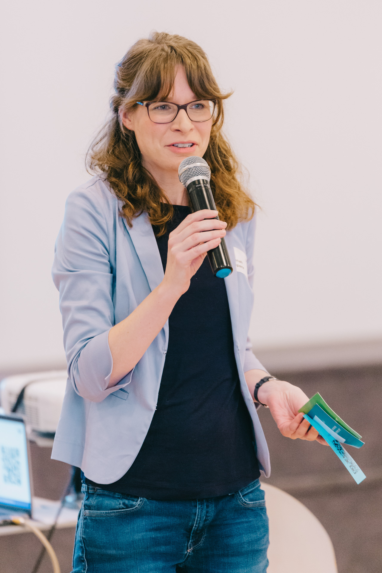 Das Foto zeigt eine Frau mit Mikrofon während einer Präsentation.